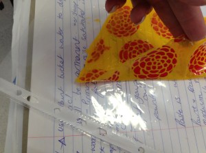 Red paint applied through a stencil onto plastic then overpainted with yellow acrylic. When dry this leaves a peel off "plastic" item to scrapbook or textile art.