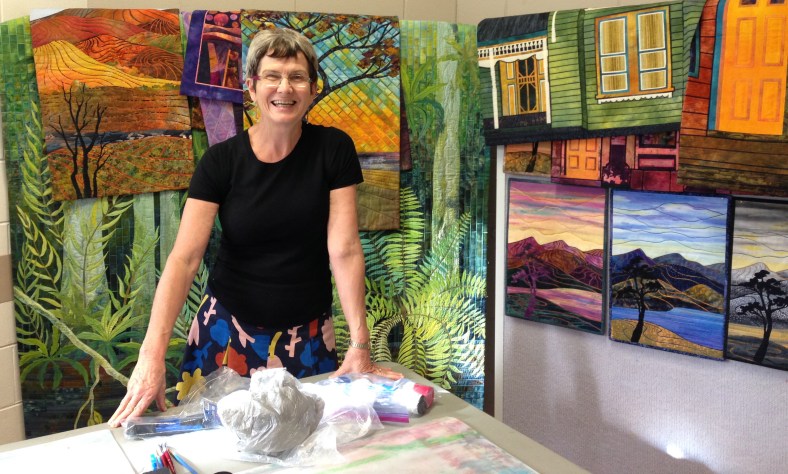 Gloria Loughman in front of her quilts